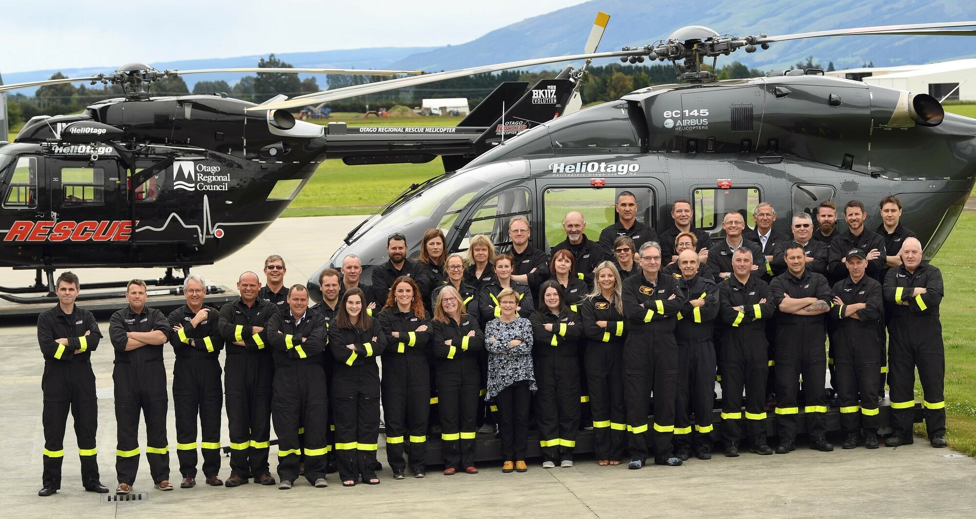 HeliOtago team members standing in front of a rescue helicopter